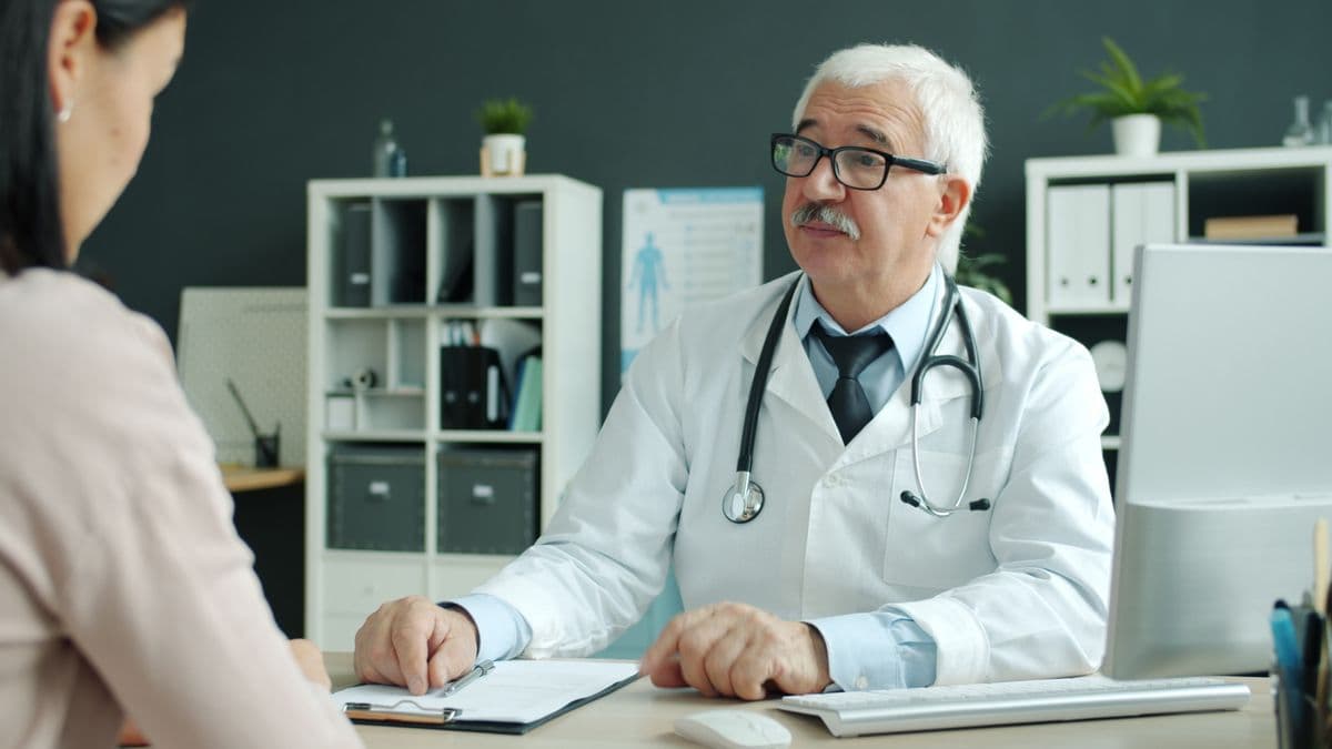 A physician discussing care with a patient in a modern medical office